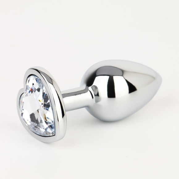 Серебристая анальная пробка с прозрачным кристаллом в форме сердца - 7 см.